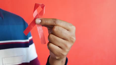 Hand-holding-red-hiv-ribbon-with-copy-space