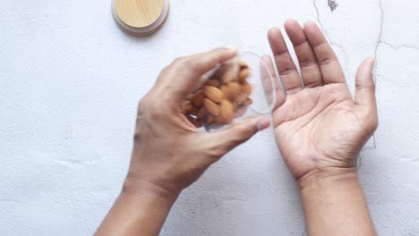 Close-up-of-almond-nuts-on-mans-hand