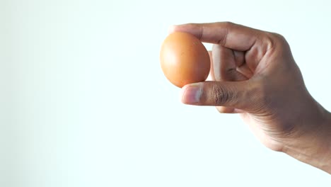 Men-holding-a-egg-against-white-background