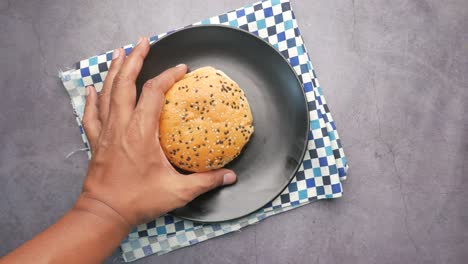 Top-view-of-hand-pick-a-beef-burger-on-table