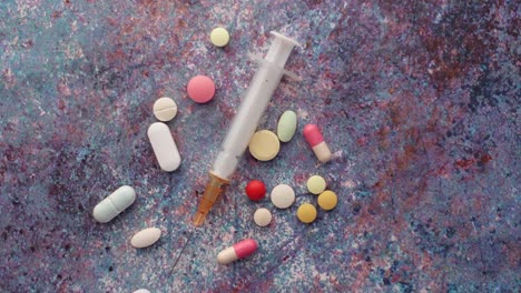 Syringe-and-pills-on-dark-background,-close-up