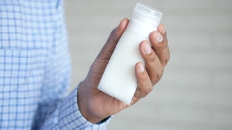 Man-hand-hold-a-cream-container
