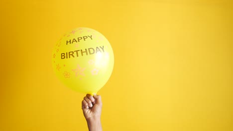 Holding-a-ballon-with-birthday-text