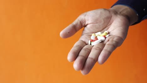 Männerhand-Mit-Aus-Dem-Behälter-Verschütteten-Pillen