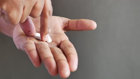 Mans-hand-with-pills-spilled-out-of-the-container
