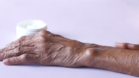 Senior-woman-applying-beauty-cream-onto-skin