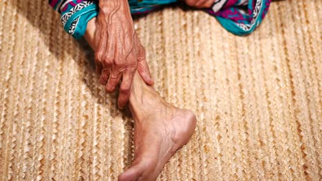 Close-up-on-senior-women-feet-and-hand-massage-on-injury-spot