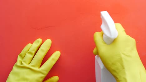 Hand-in-yellow-rubber-gloves-holding-spray-bottle-with-copy-space-,