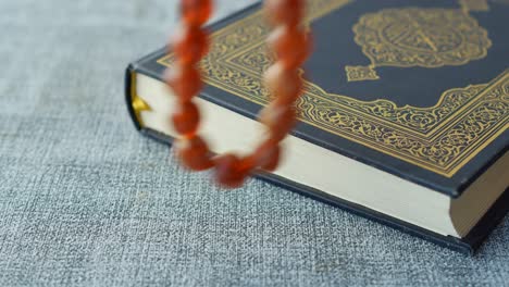 Holy-book-quran-and-rosary-on-table,-close-up