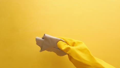 Hand-in-yellow-rubber-gloves-cleaning-table-with-cloth