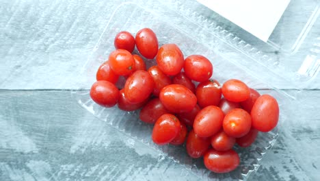 Red--small-tomato-in-a-plastic-container-,