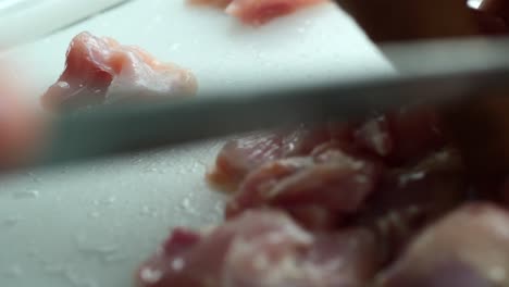 Person-hand-cutting-chicken-meat-close-up-,
