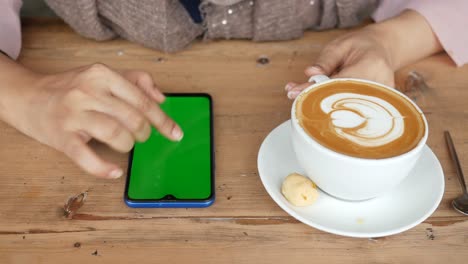 Holding-a-cpu-of-coffee-and-using-smart-phone-with-green-screen