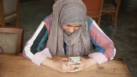 Young-muslim-women-using-smart-phone-at-cafe