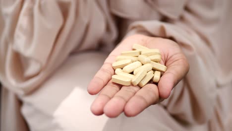 Close-up-of-women-hand-taking-pills