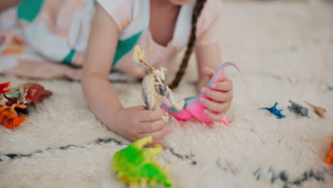 Girl,-play-and-dinosaur-toys-on-floor-with-animals