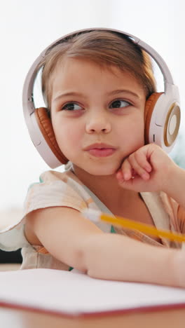 Writing,-homework-and-child-with-headphones