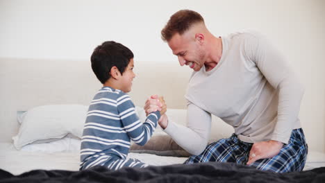 Man,-boy-and-arm-wrestle-for-fun-in-home