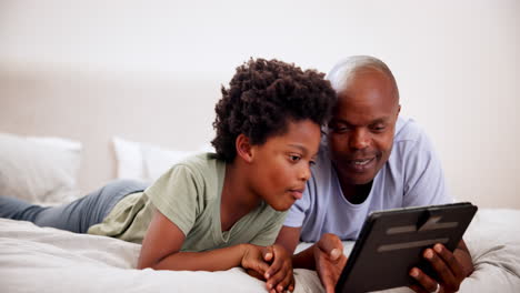 Father,-smile-and-black-kid-on-tablet-in-bedroom