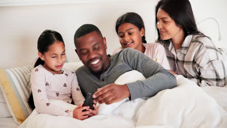 Parents,-girl-children-and-bed-with-phone