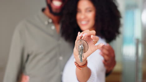 Closeup,-keys-and-couple-with-new-home