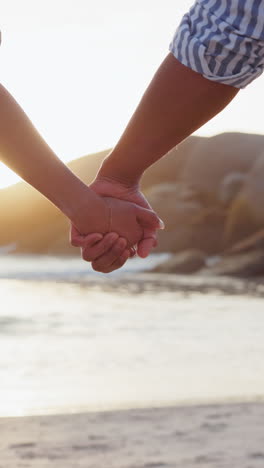 Love,-freedom-and-couple-holding-hands-with-beach