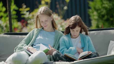 Zwei-Mädchen-Lesen-Bücher-Und-Sitzen-Auf-Einer-Gartenschaukel-Im-Hinterhof-Des-Hauses