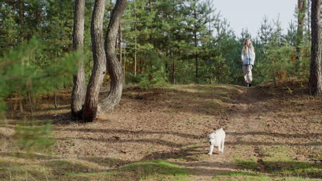 Teenage-girl-walking-in-the-forest-with-a-dog