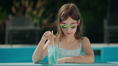 Teenage-girl-crushes-ice-in-a-cocktail-on-the-side-of-the-pool