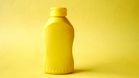 Mustard-mayonnaise-in-yellow-container-on-yellow-background-,