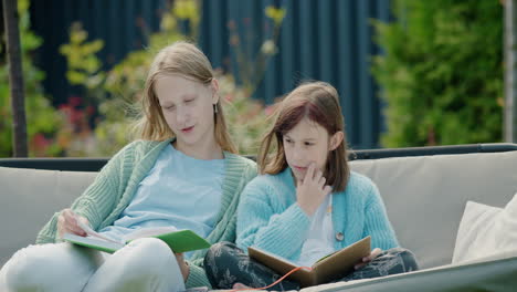 Zwei-Teenager-Mädchen-Lesen-Bücher-Und-Sitzen-Auf-Einer-Gartenschaukel-Im-Hinterhof-Des-Hauses