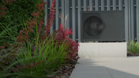 The-heat-pump-for-heating-the-pool-is-mounted-on-site.-Ornamental-plants-nearby.-Energy-Saving-Technologies.-Slider-shot