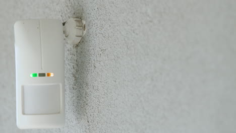 Motion-sensor-on-the-wall-of-the-house.-LED-indicators-light-up-to-detect-movement