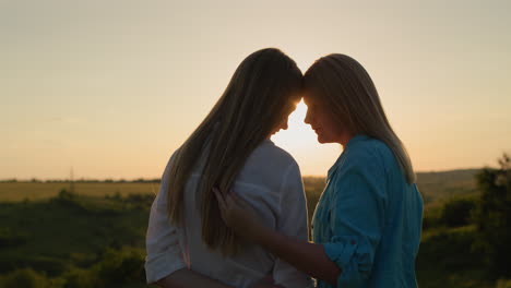 Tender-portrait-of-mom-and-teen-daughter-at-sunset
