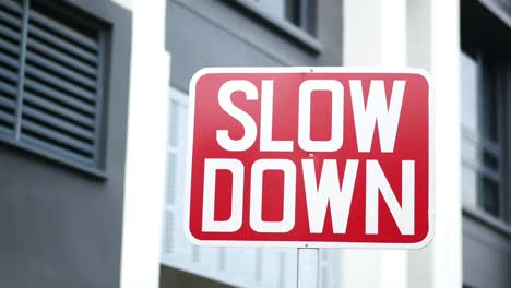 Close-up-of-slow-down-sign-against-building-,