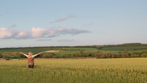 Happy-woman-enjoying-majestic-rural-landscape-with-wheat-field