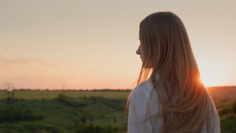 Teenage-girl-turns-her-head-and-long-hair-at-sunset.-Slow-motion-video