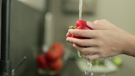 Frauenhände-Waschen-Eine-Paprika-Unter-Leitungswasser.-Zeitlupenvideo