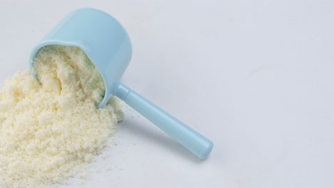 Close-up-of-baby-milk-powder-and-spoon-on-tile-background