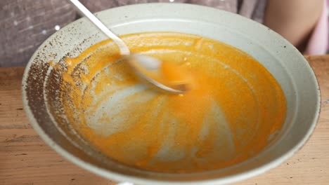 Stirring-a-bowl-of-yellow-vegetables-soup
