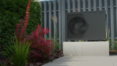 The-heat-pump-for-heating-the-pool-is-mounted-on-site.-Ornamental-plants-nearby.-Energy-Saving-Technologies
