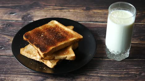 Glass-of-milk-and-toasted-bread-on-table-,