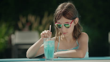 Teenage-girl-crushes-ice-in-a-cocktail-on-the-side-of-the-pool