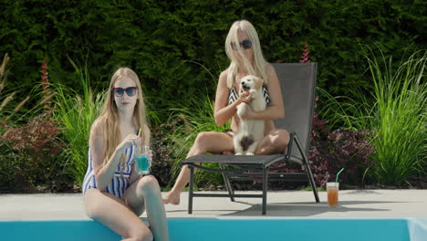 Mom,-daughter-and-puppy-are-relaxing-by-the-pool.-Good-time-together,-family-vacation