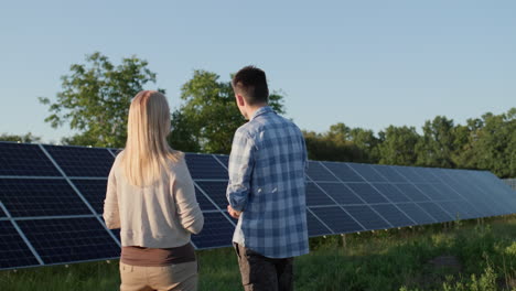 Two-people-are-talking-around-solar-panels-at-a-small-home-solar-power-plant.-Ecologically-clean-production-of-electricity