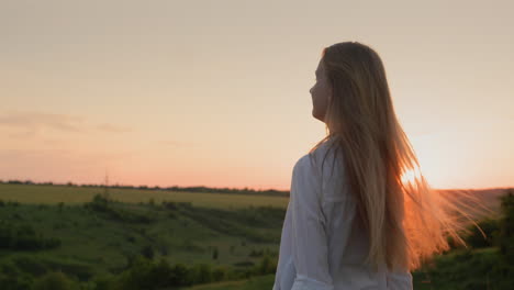 Teenage-girl-turns-her-head-and-long-hair-at-sunset.-Slow-motion-video