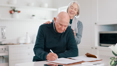 Senior-couple,-hug-and-kitchen-with-paperwork