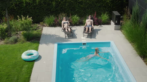 Eine-Familie-Mit-Kind-Entspannt-Am-Kleinen-Pool-Ihrer-Villa.-Eltern-Sonnen-Sich,-Kind-Schwimmt