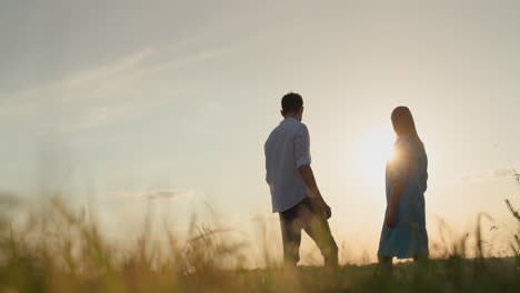 A-married-couple-stands-at-sunset-and-looks-ahead.-Relationships-and-family-concept