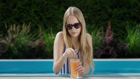 Porträt-Eines-Teenager-Mädchens-Im-Pool-Mit-Einem-Glas-Erfrischungsgetränk